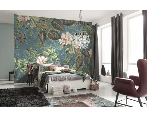 Slaapkamer met bloemenbehang, bed, tapijt en fauteuil