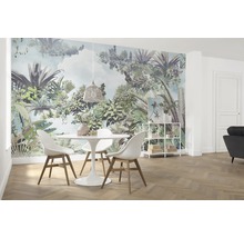 Lichte eetkamer met junglebehang, eettafel en stoelen.