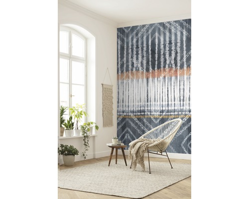 Woonkamer met patroonbehang, fauteuil, vloerkleed en kamerplanten