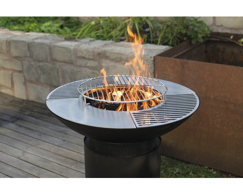 Vuurplaats met grillrooster en brandend hout in de tuin