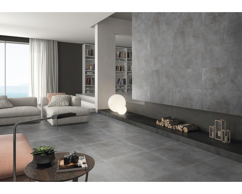 Lichte woonkamer met grijze vloertegels, open haard en boekenkasten