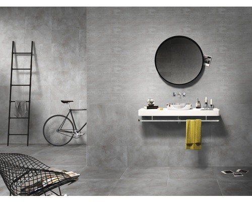 Moderne badkamer met grijze tegels, ronde spiegel en minimalistisch meubilair.