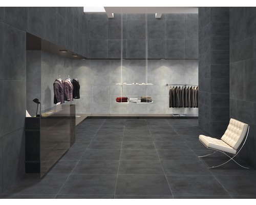 Interieur met grijze tegels op vloer en muren, lichte fauteuil