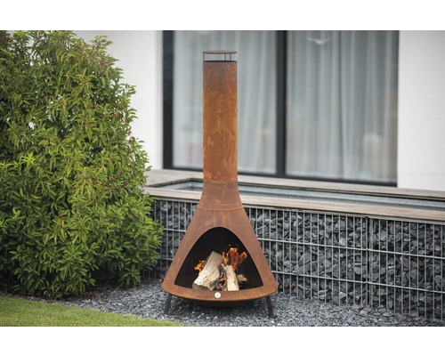 Tuin met een metalen Chiminea tuinhaard en brandend hout