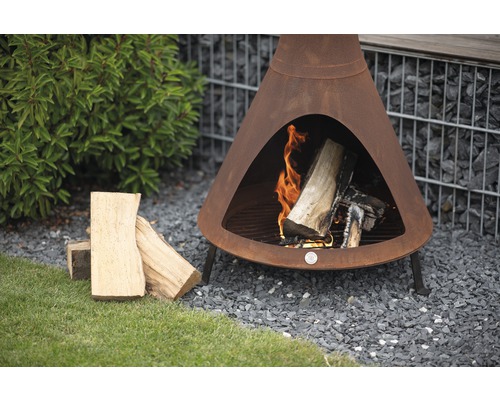 Tuinscene met een chimenea houtkachel, houtblokken en grind