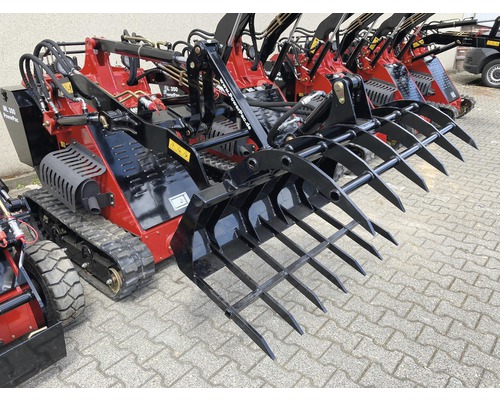 Meerdere rode PowerPac miniladers met zwarte aanbouwdelen staan op een bestrate ondergrond.