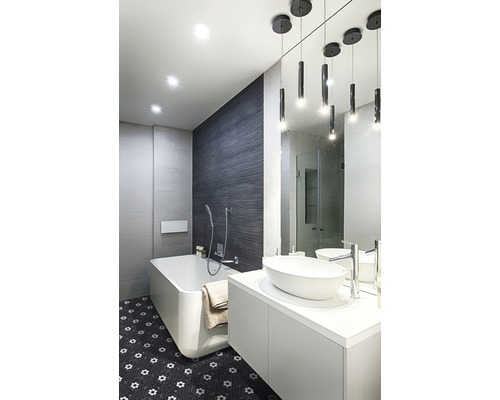 Badkamer met bad, wastafel en spiegel