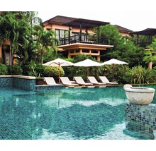 Zwembad met ligstoelen en parasols voor een gebouw