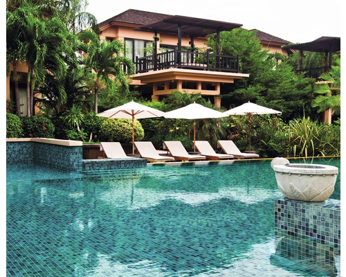 Zwembad met ligstoelen en parasols voor een gebouw