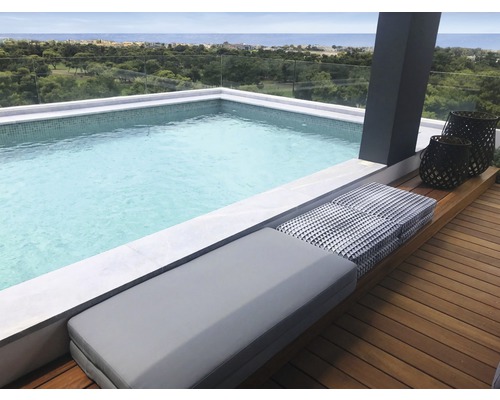 Scène met zwembad, zitbank en decoratieve lantaarns op een dakterras met uitzicht op zee