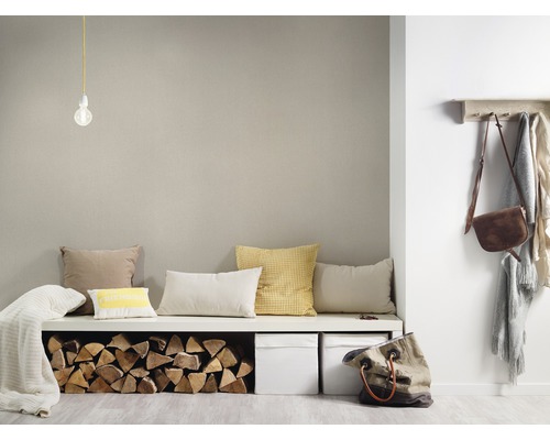 Woonkamer met zitbank, kussens, houtblokken, opbergdozen, kapstok en accessoires.