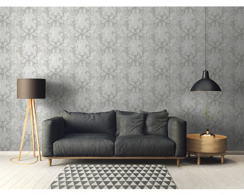 Woonkamer met patroonbehang, bank, vloerlamp en bijzettafel