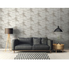 Woonkamer met bank, staande lamp en behang met bosmotief