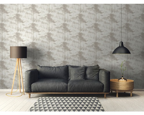 Woonkamer met bank, staande lamp en behang met bosmotief