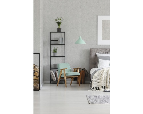 Slaapkamer met bed, fauteuil, rek en hanglamp