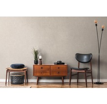 Woonkamer met dressoir, stoel en staande lamp op parketvloer