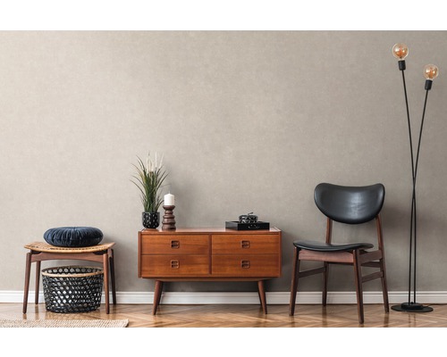 Woonkamer met dressoir, stoel en staande lamp op parketvloer