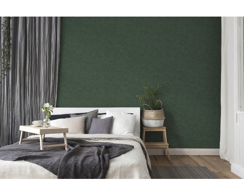 Slaapkamer met bed, houten dienblad, plant en groen behang