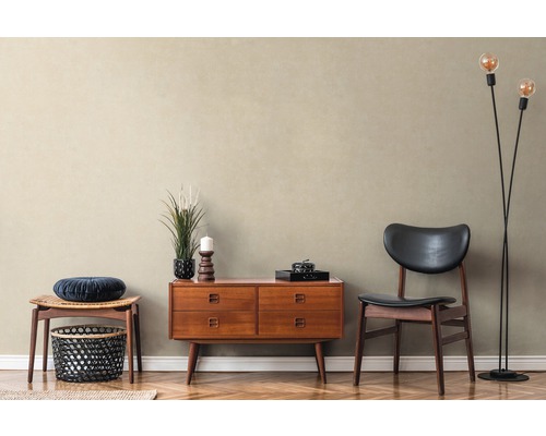 Woonkamer in retrostijl met ladekast, stoel, kruk en staande lamp