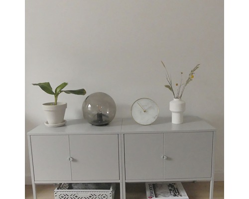 Dressoir met kamerplant, tafellamp, klok en vaas