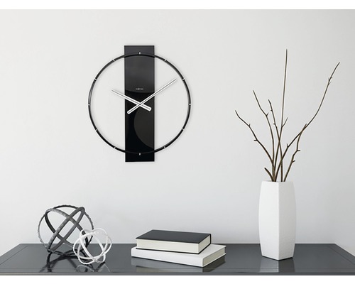 Wandklok met metalen wijzers en decoratie op een dressoir