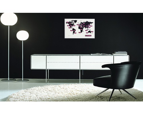 Interieur met twee staande lampen, een dressoir, een fauteuil en een wereldkaart aan de muur.