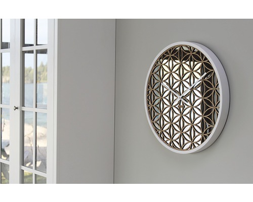 Ronde wandklok met bloemmotief aan een muur