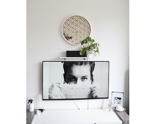 Woonkamer met geometrische wandklok en televisie