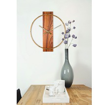 Wandklok met houten details en gouden accenten boven een houten tafel met decoraties.