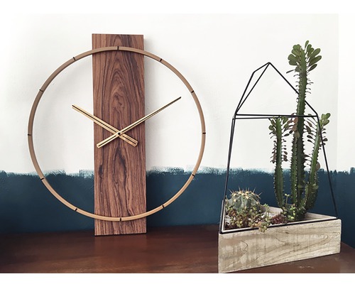 Decoratieve scène met een houten wandklok en een succulenten terrarium.