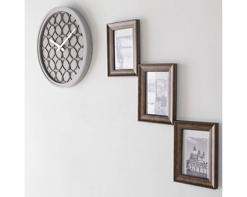 Wandklok en drie fotolijsten aan de muur