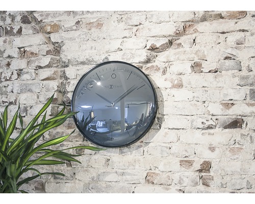 Nextime wandklok aan een bakstenen muur