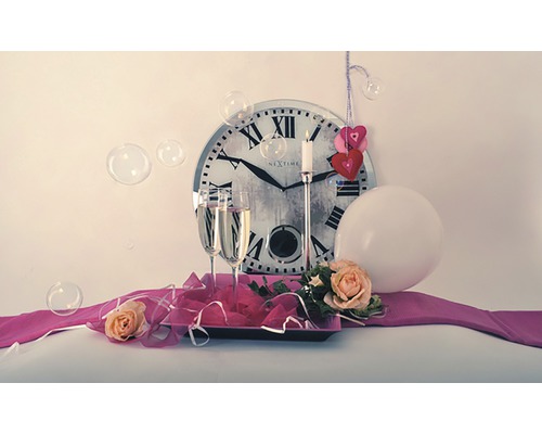 Decoratie met klok, champagneglazen, kaars, ballon en rozen