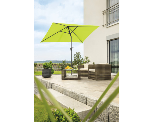 Vierkante parasol op een terras met tuinmeubelen voor een huis.