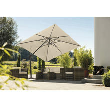 Vierkante zweefparasol boven rotan zithoek in de tuin
