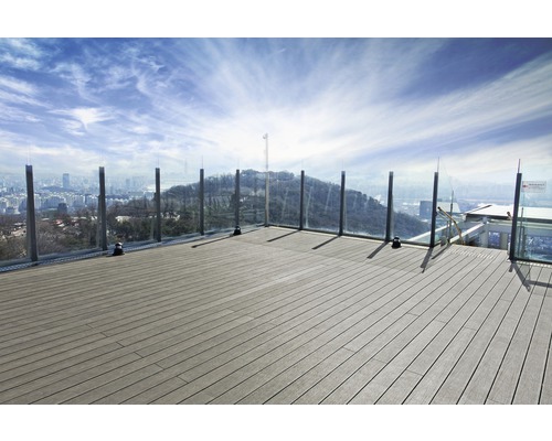 Terras met houten planken en glazen balustrade met uitzicht op een stad