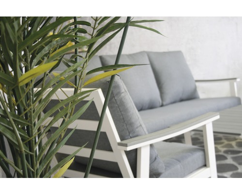 Tuinmeubelset met grijze kussens en bamboeplant