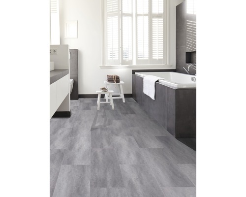 Lichte badkamer met grijze vinyl vloertegels, bad en wit sanitair.