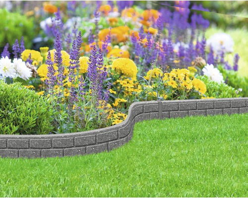 Tuinborderrand van steen met bloemen en gras
