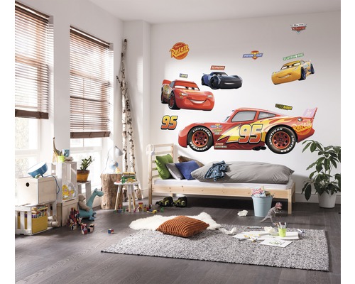 Kinderkamer met muurstickers van Cars-motieven, bed en speelgoed