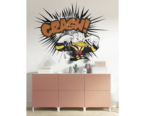 Wanddecoratie met Donald Duck motief boven een dressoir.