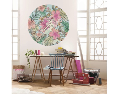 Woonkamer scène met een ronde muurdecoratie met zeemeermin en bloemmotief boven een tafel