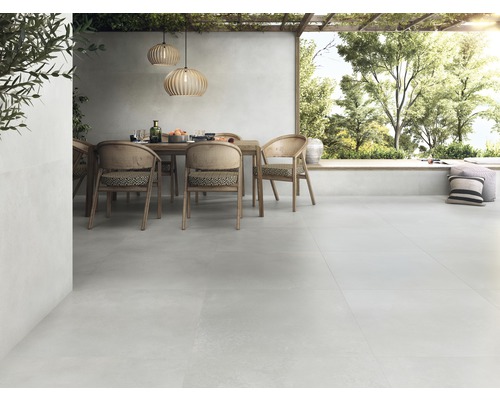 Terras met terrastegels, eettafel en stoelen onder een pergola