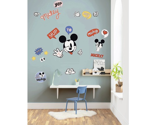 Wanddecoratie met Mickey Mouse muurstickers in een kinderkamer boven een bureau.