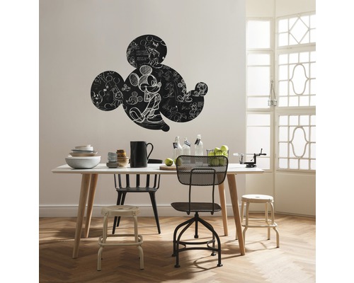 Woonkamer met eettafel, stoelen en Mickey Mouse muursticker