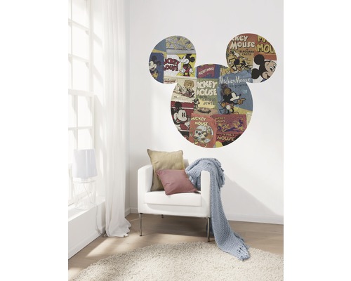 Woonkamer met een fauteuil, een deken en een muursticker in de vorm van Mickey Mouse