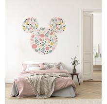 Decoratieve kinderkamer met muursticker in de vorm van een Mickey Mouse met bloemmotief boven een bed.