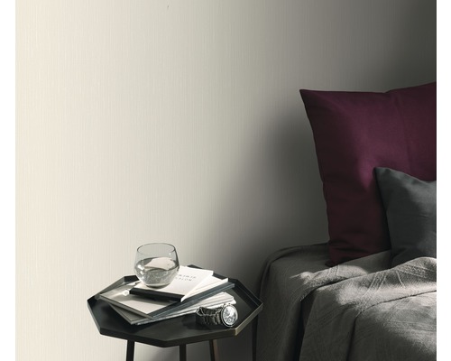 Lichtkleurig behang in slaapkamer met nachtkastje en bed