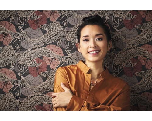 Vrouw voor een muur met behang met vismotief