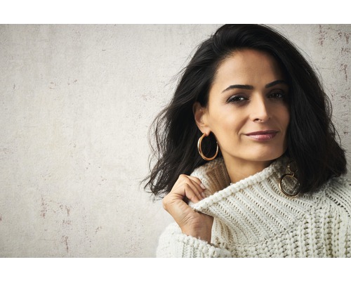 Portret van een vrouw met een gebreide trui en oorbellen